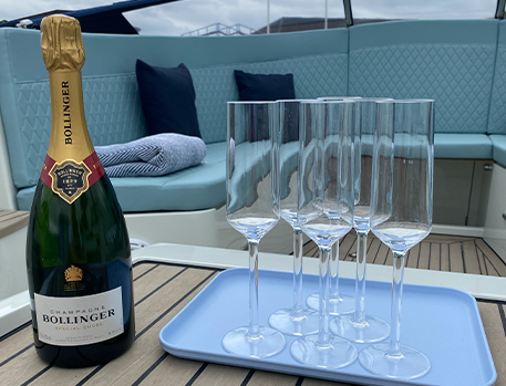 Bottle of Bollinger champagne and flutes on a tray, on a boat.