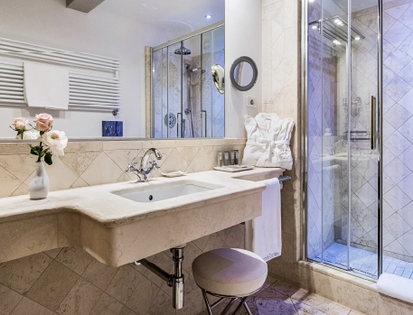 Elegant bathroom suite at Monastero di Cortona Hotel, Tuscany, featuring a walk-in shower, marble countertops, and luxury amenities for a refined experience.