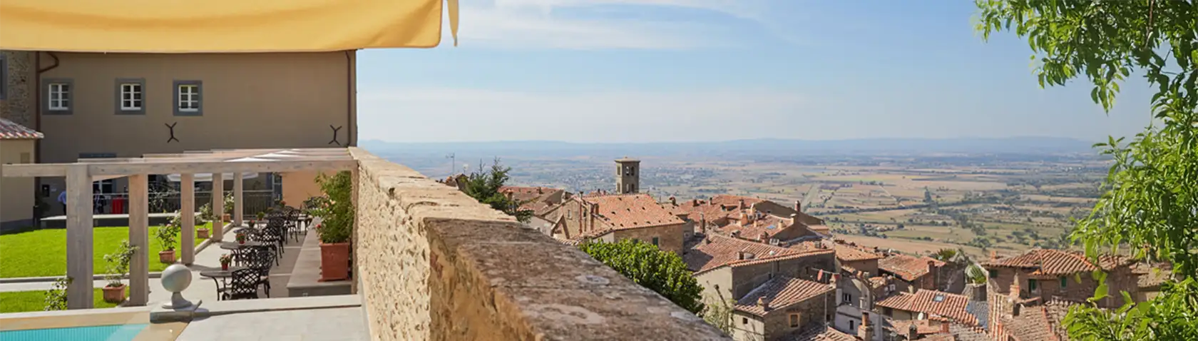 Stunning terrace view overlooking the historic rooftops of Cortona and the Tuscan countryside from Monastero di Cortona Hotel, Italy.